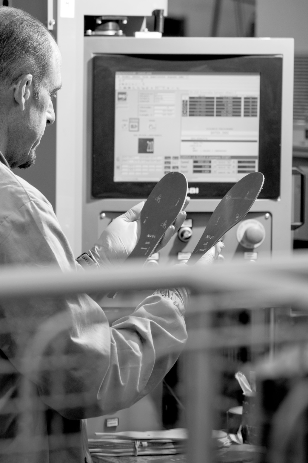 Artigiano che controlla un paio di suole realizzate